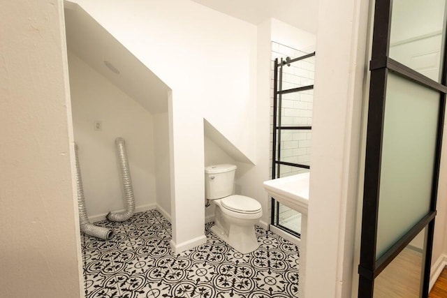 bathroom featuring sink, tile patterned floors, toilet, and tiled shower