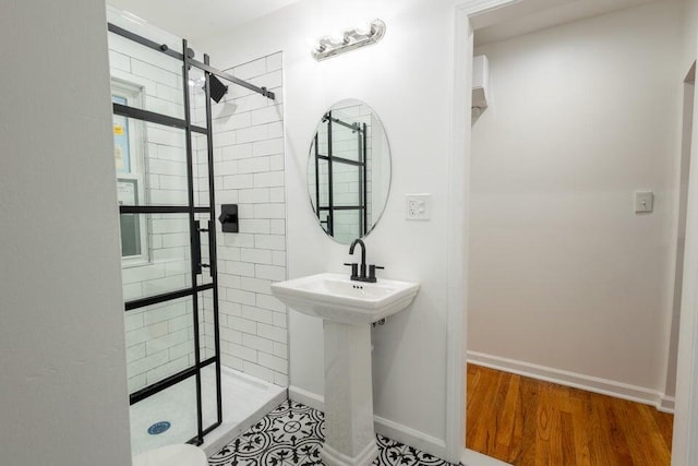 bathroom featuring hardwood / wood-style flooring, sink, and a tile shower