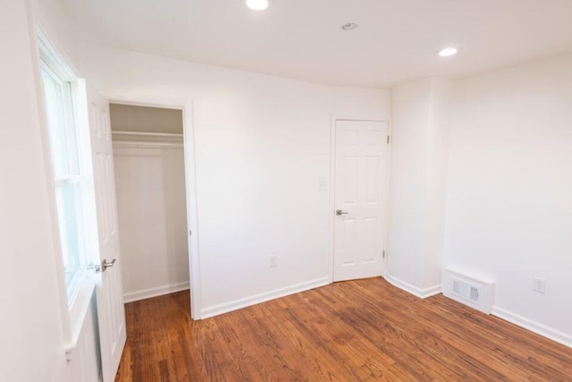 unfurnished bedroom featuring dark wood-type flooring and a closet