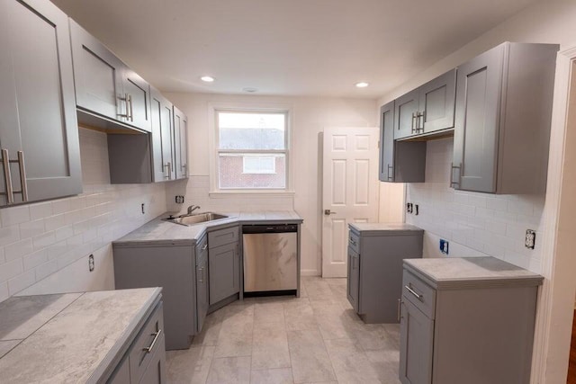 kitchen with gray cabinetry, dishwasher, and sink