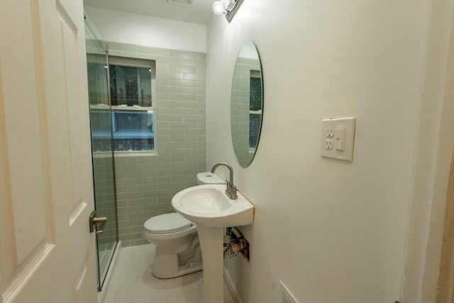 bathroom with toilet, tile patterned floors, and sink