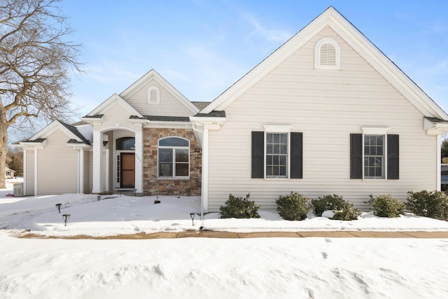 view of front facade featuring stone siding and central AC unit