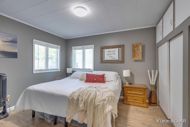 bedroom with crown molding and light hardwood / wood-style floors