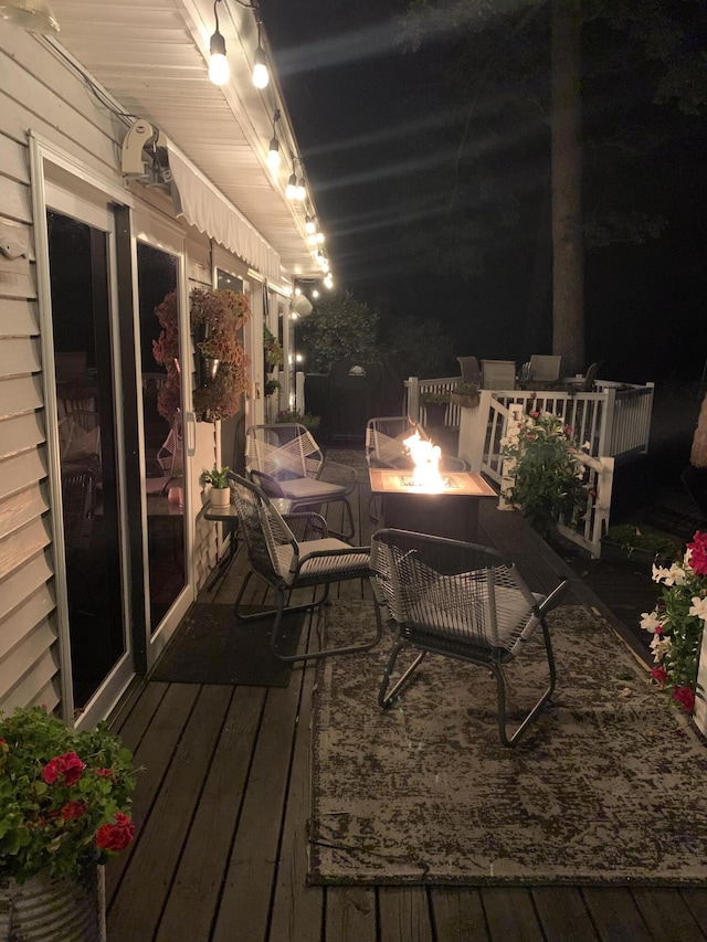 deck at night featuring a fire pit