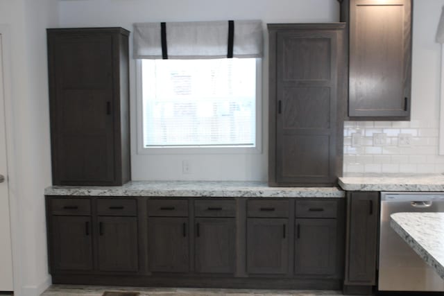 kitchen with decorative backsplash, dishwasher, light stone counters, and dark brown cabinetry