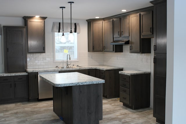 kitchen featuring stainless steel dishwasher, a center island, tasteful backsplash, and sink