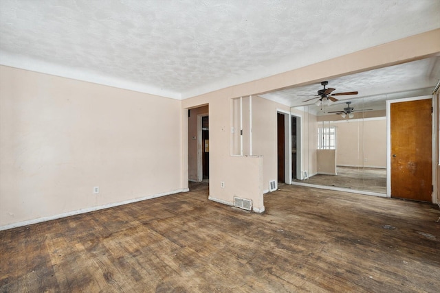 empty room featuring a textured ceiling, ceiling fan, and dark hardwood / wood-style flooring