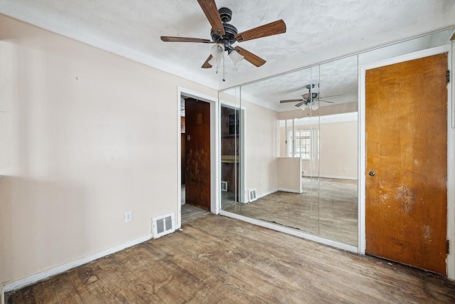 unfurnished room featuring a textured ceiling, ceiling fan, and wood-type flooring