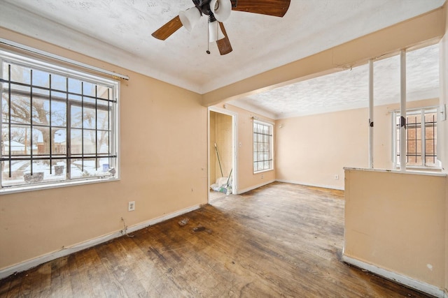 unfurnished living room featuring ceiling fan, a textured ceiling, and hardwood / wood-style flooring