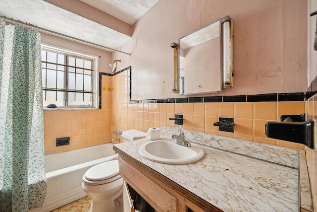 full bathroom featuring tile walls, toilet, vanity, and shower / bath combo