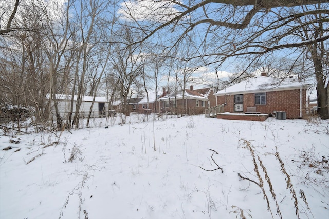 yard covered in snow featuring a deck and central air condition unit