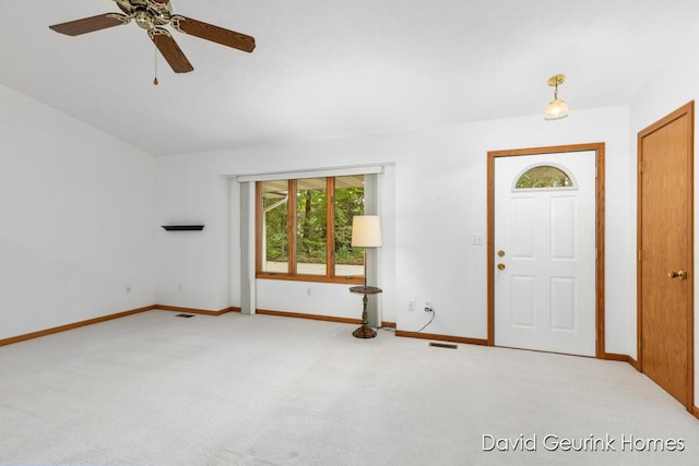 foyer entrance featuring ceiling fan, light colored carpet, and plenty of natural light