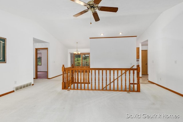 hallway featuring lofted ceiling, light colored carpet, and a notable chandelier