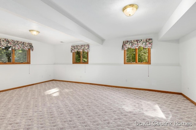 unfurnished room featuring carpet floors and beam ceiling