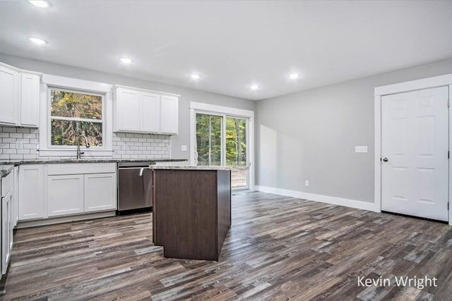 kitchen featuring stainless steel dishwasher, white cabinets, tasteful backsplash, and sink