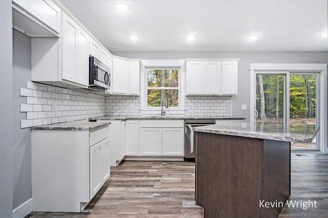 kitchen featuring dark wood-type flooring, appliances with stainless steel finishes, white cabinetry, and sink