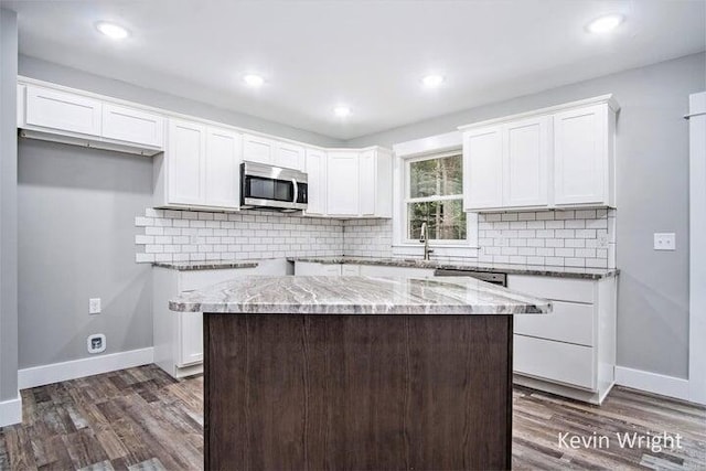 kitchen featuring appliances with stainless steel finishes, white cabinets, and a center island