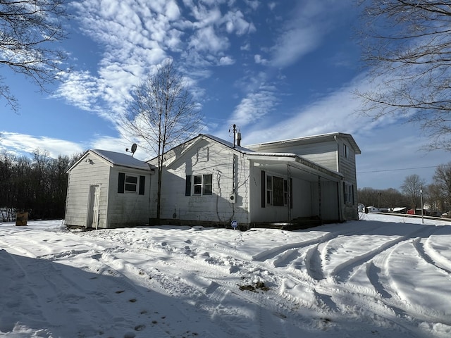 view of snow covered rear of property