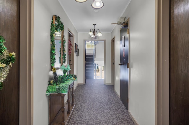 hall featuring an inviting chandelier, crown molding, and baseboards