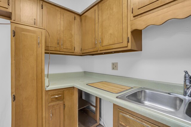 kitchen featuring light countertops, a sink, and brown cabinets
