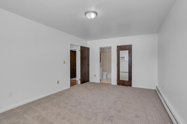 unfurnished bedroom with baseboards, ensuite bathroom, carpet, and a baseboard radiator