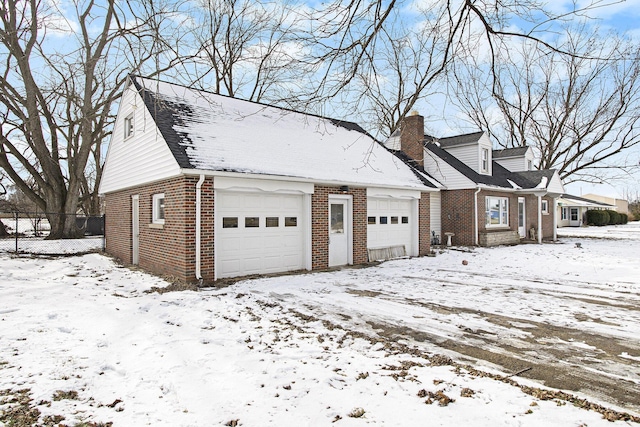 view of snowy exterior with a garage