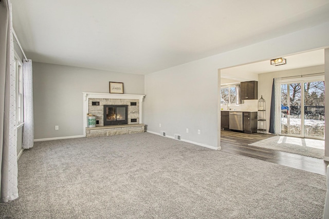 unfurnished living room with dark carpet and a fireplace