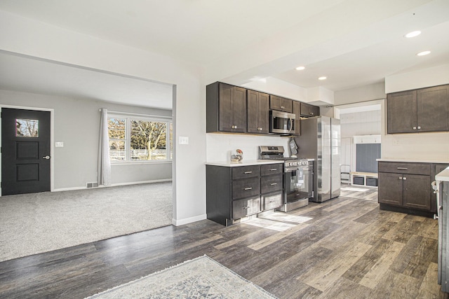 kitchen featuring appliances with stainless steel finishes, dark wood-type flooring, and dark brown cabinetry