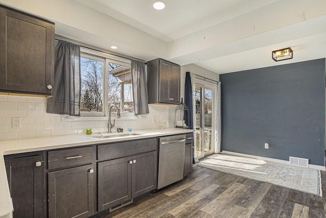 kitchen with dark hardwood / wood-style floors, dishwasher, sink, backsplash, and dark brown cabinets