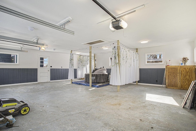 garage with a garage door opener and wood walls