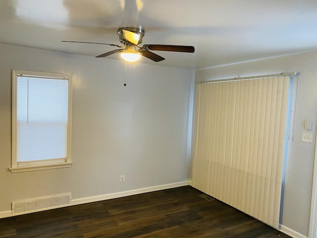 empty room with dark hardwood / wood-style floors and ceiling fan