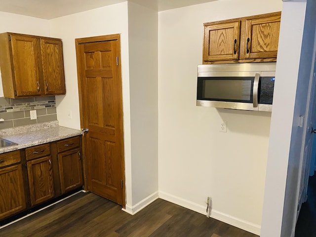 kitchen featuring dark hardwood / wood-style floors and backsplash