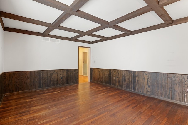 unfurnished room featuring coffered ceiling, dark wood-type flooring, beam ceiling, and wood walls