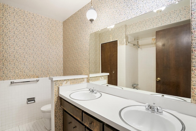 bathroom with tile patterned flooring, vanity, tile walls, and toilet