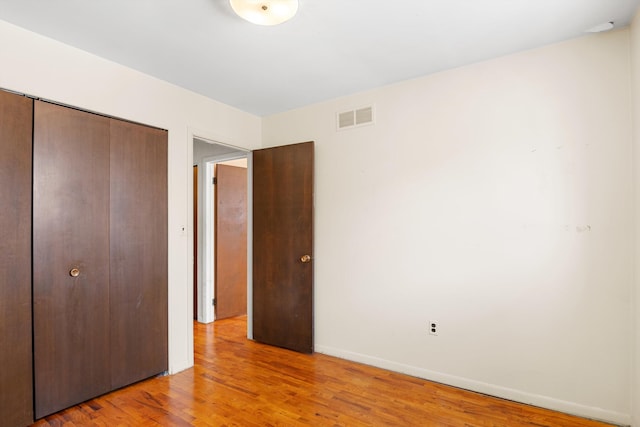 unfurnished bedroom with light hardwood / wood-style flooring and a closet