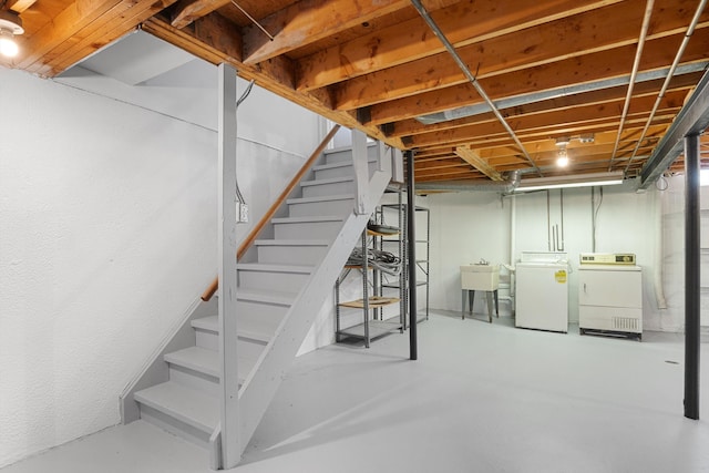 basement with washing machine and clothes dryer and sink