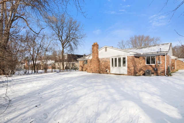 snow covered back of property with central AC unit