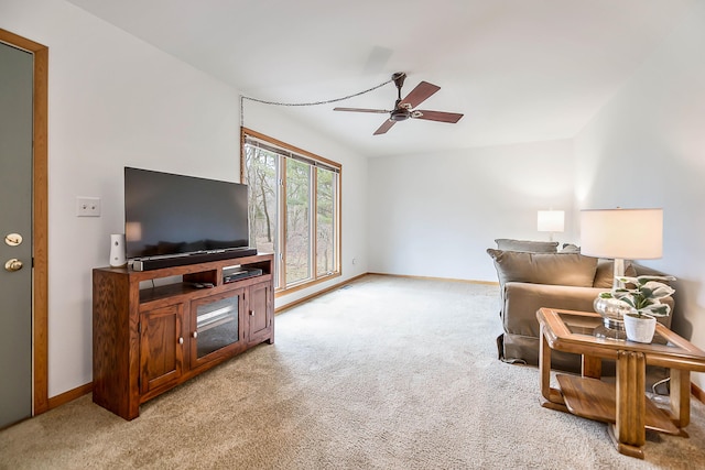 living area with light carpet, ceiling fan, and baseboards