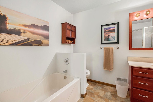 bathroom featuring toilet, vanity, and a bathtub