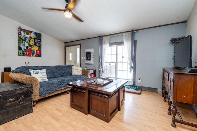 living room featuring ceiling fan, lofted ceiling, and light hardwood / wood-style flooring