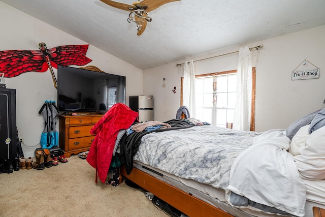 bedroom featuring ceiling fan, carpet, lofted ceiling, and a textured ceiling