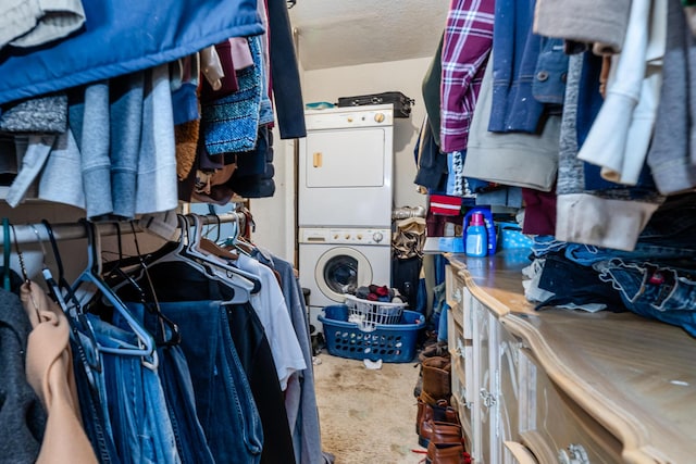 spacious closet featuring stacked washer and dryer and carpet flooring