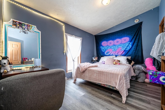 bedroom featuring a textured ceiling, lofted ceiling, and hardwood / wood-style flooring