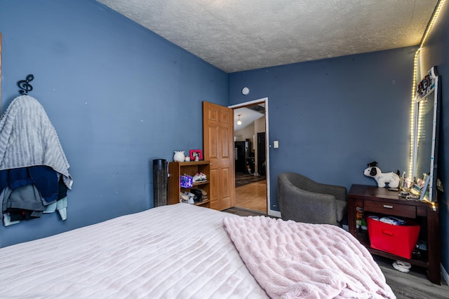 bedroom featuring wood-type flooring and a textured ceiling