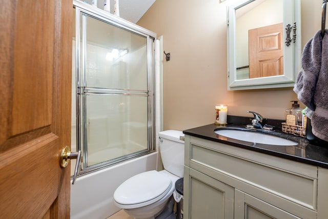 full bathroom featuring toilet, combined bath / shower with glass door, and vanity