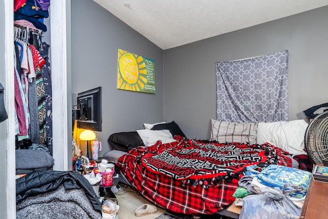 bedroom featuring lofted ceiling, a closet, and carpet flooring