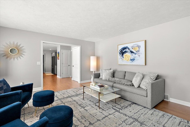 living room with wood-type flooring and a textured ceiling