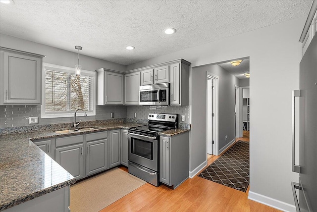 kitchen featuring gray cabinets, appliances with stainless steel finishes, and sink