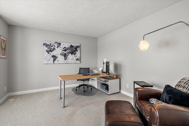 carpeted office featuring a textured ceiling