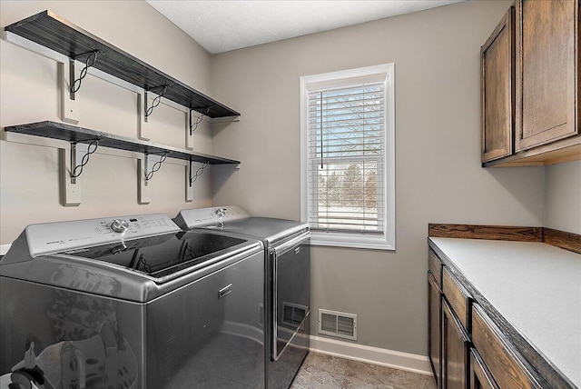 laundry room featuring washing machine and dryer and cabinets